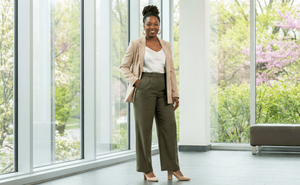 spring outfits black woman olive green trousers white silk top beige blazer standing office lobby windows