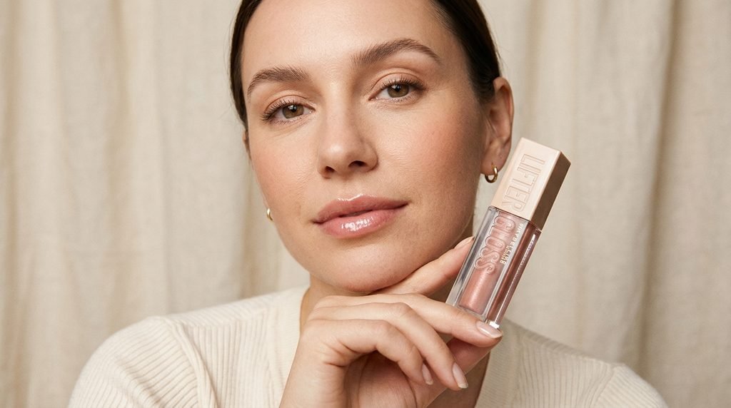 Lifter Gloss lip gloss tube with a glossy nude-pink finish in an elegant beauty product setting.