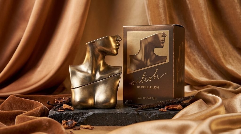 Billie Eilish Eilish Eau de Parfum gold sculptural perfume bottle and packaging.